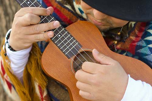 guitar person playing brown ukulele leisure activities
